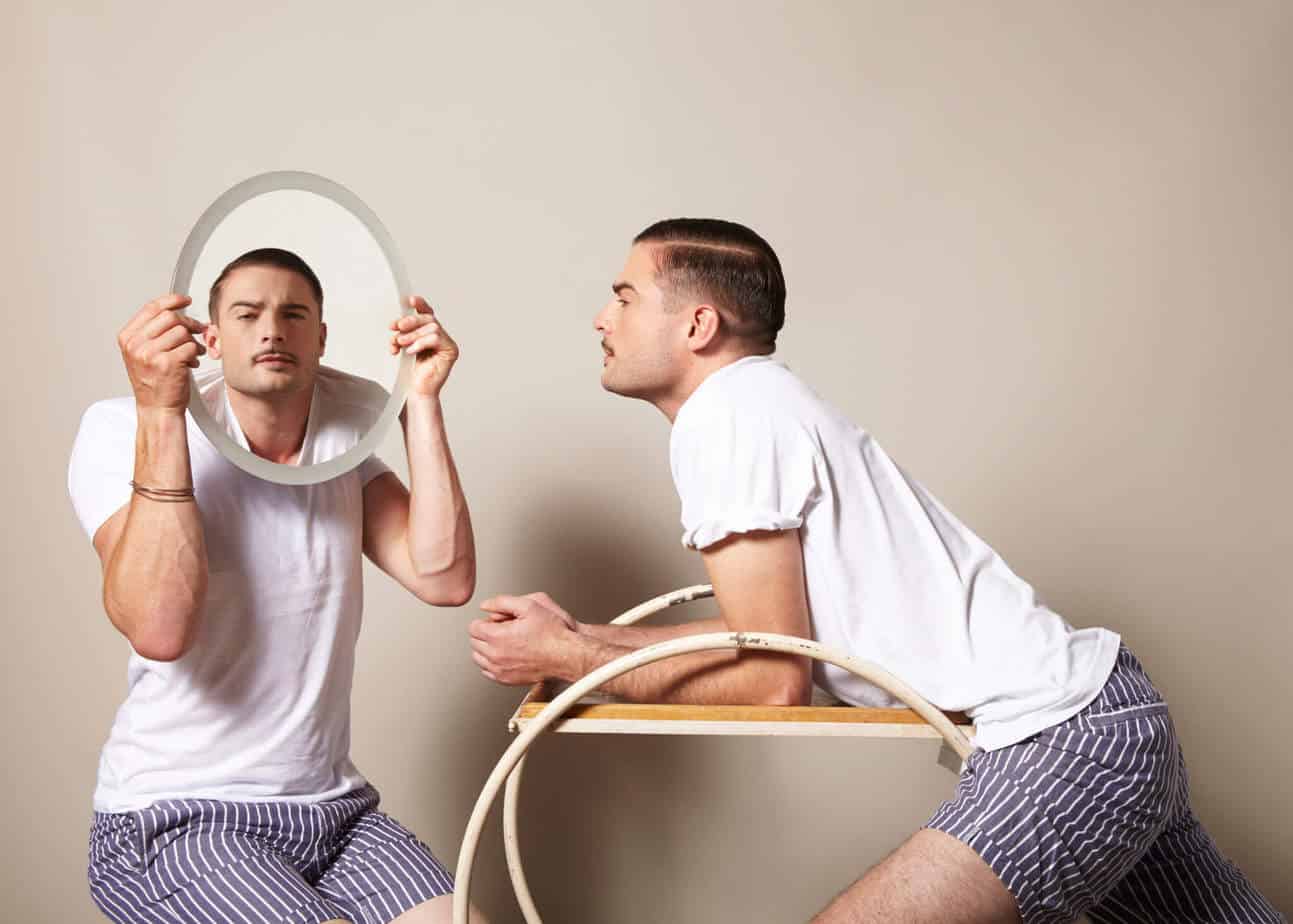 Mężczyzna wpatrzony we własne odbicie w lustrze